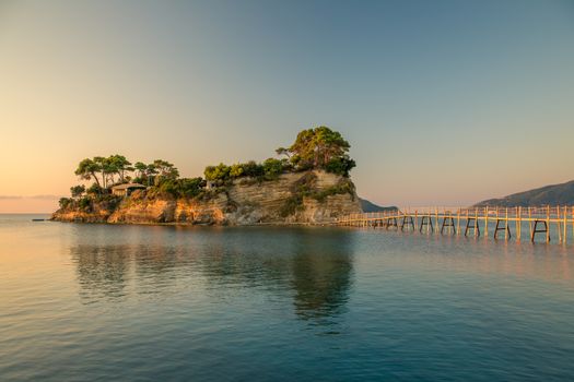 Beautiful sunrise, just before the storm rains. The famous Cameo island. A beautiful small island with wooden bridge and turquoise water. Zakynthos Greece.