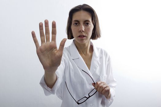 Doctor woman with raised open palm on white background