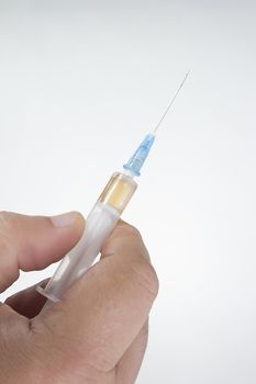 Medical syringe in a male hand on a white background