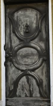 A view of an ancient door color silver, typical in old houses in Piedmont.