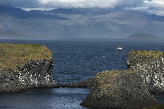 Icelandic Landscape. Seashore of the Atlantic Ocean with Mountains and basalt rocks.