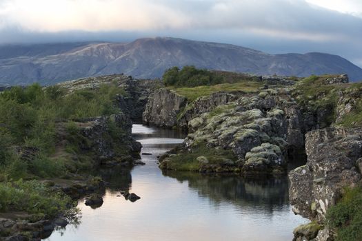 Typical icelandic landscape with volcanoes, mountains and river at sunset.