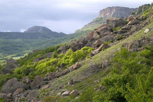 mountain landscape, rock and stone chaos, against the cloud  sky