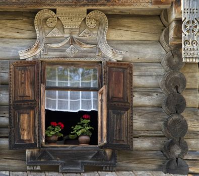 window with shutter and part of wooden wall of the  old russian  house,  with flowers on the windowsill