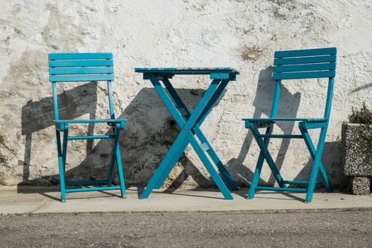 pictoresque blue chairs on a street in a village in swiss