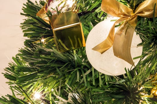 close-up view of a Christmas tree decorated with white balls and Golden ribbons