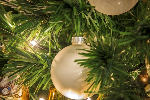close-up view of a Christmas tree decorated with white balls and Golden ribbons