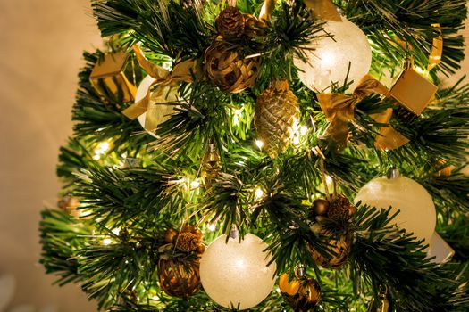 close-up view of a Christmas tree decorated with white balls and Golden ribbons