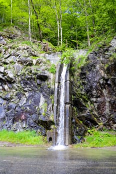 A mountain stream flows through dense forests. Out of focus