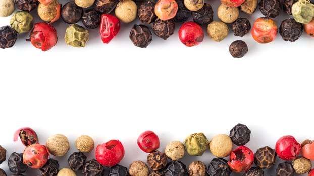 Mixed peppercorns background with white copy space in center. Food background with peppercorns. Different colored peppercorns pattern on white background, top view or flat lay