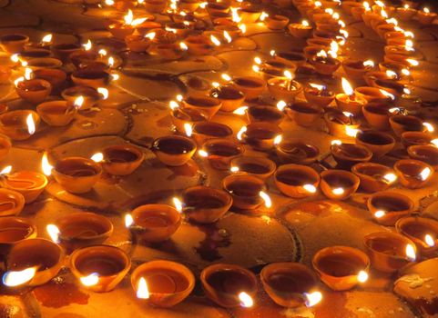 Traditional earthen lamps set on the floor for Diwali festival in India.                               