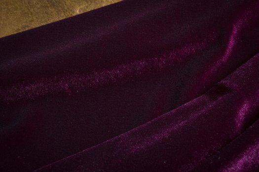 Purple velor fabric on a wooden surface