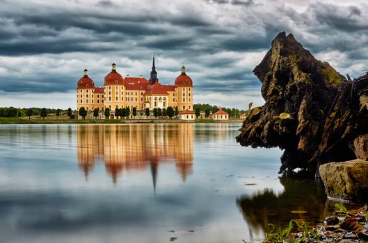 Castle of Moritzburg with smooth water, wood and stormy sky