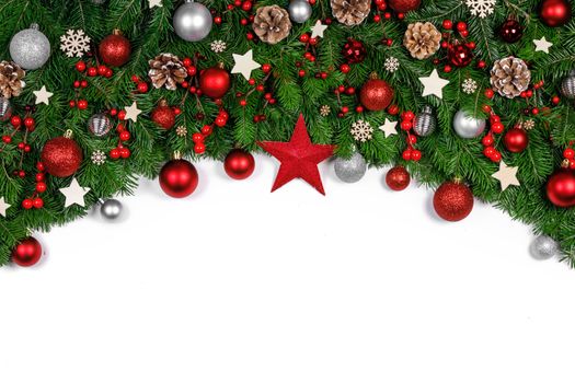 Christmas Border frame of tree branches on white background with copy space isolated, red and golden decor, berries, stars, cones