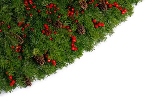 Christmas Border frame of tree branches red berries and pine cones on white background with copy space isolated