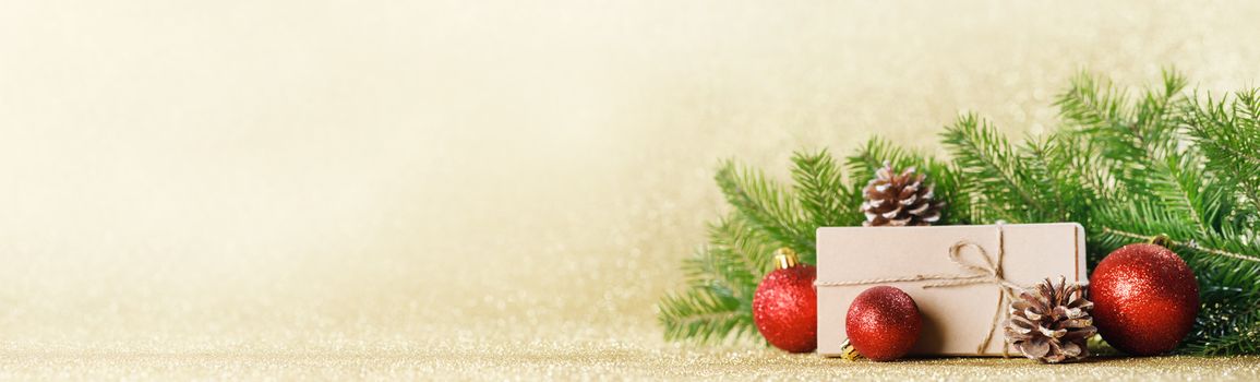 Christmas toys, decorations, present gift box wrapped in kraft paper on golden glitter background, copy space