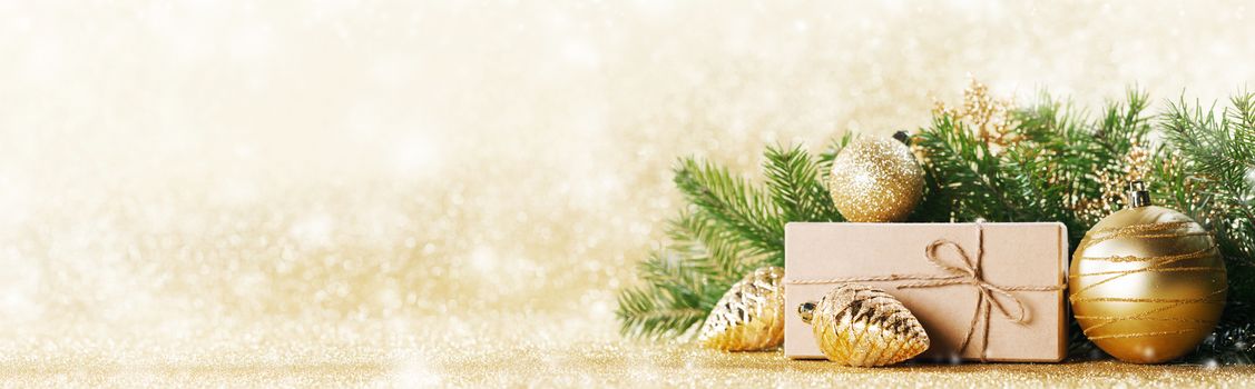 Christmas toys, decorations, present gift box wrapped in kraft paper on golden glitter background, copy space
