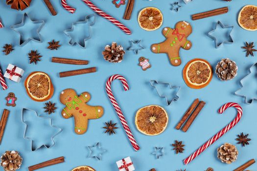 Christmas food frame. Gingerbread cookies, spices and decorations on blue background with copy space