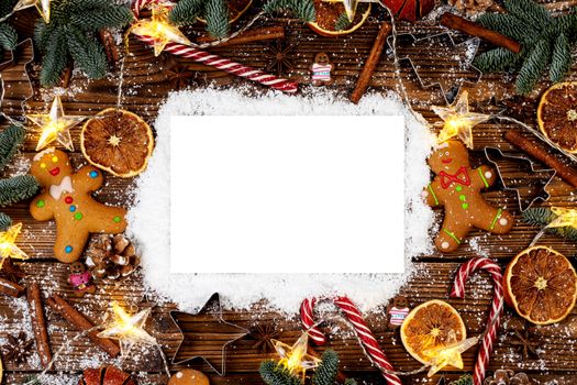 Christmas food frame. Gingerbread cookies, spices and decorations on wooden background with copy space on snow
