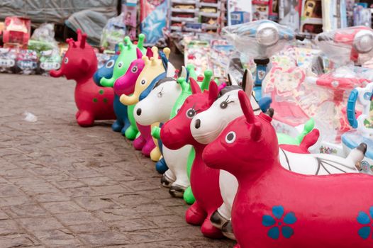 Colorful little plastic make Toys and Dolls for display in afternoon sun at the outdoor New Market Handicrafts Emporium near Esplanade Road, Kolkata. Lacquer wood finish gives it shining glowing look.