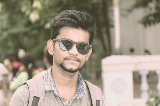 Half length portrait of attractive young a man called Ove standing outdoors outside college building and looking at camera. A High school student portrait photography on 15 October World Students Day.