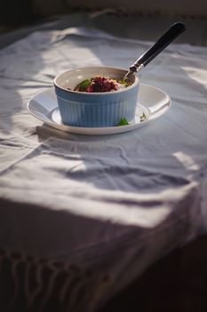 baked oat-blueberry crumble with mint in a white and blue plate on a rustic linen tablecloth. Save the space, top view. The concept of healthy proper nutrition for breakfast, vegetarianism