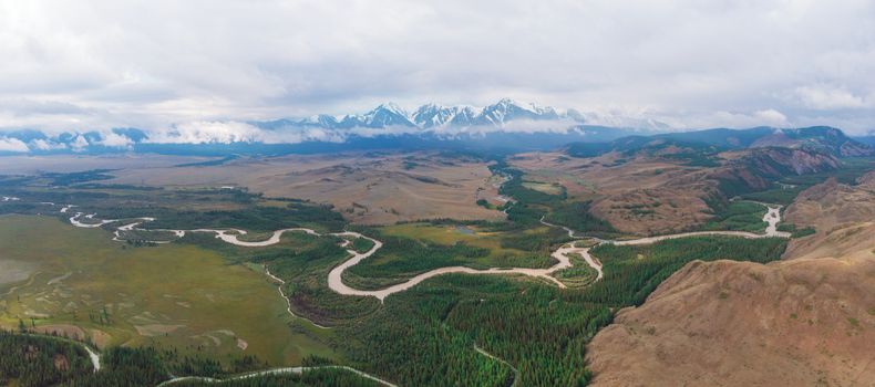 Panorama of Kurai steppe and Chuya river on North-Chui ridge background. Altai mountains, Russia. Aerial drone panoramic picture.