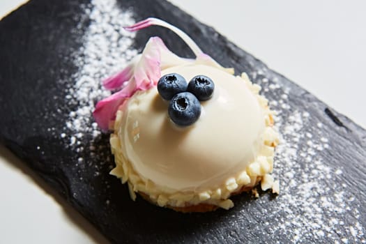 Vanilla bavarian mousse cake with cherries and dark chocolate on top. Made with cream cheese and whipped cream.