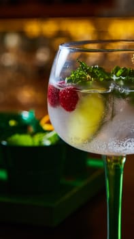 Raspberry Mojito Lemonade with lime and fresh mint in glass on wooden background. Summer refreshing cocktail