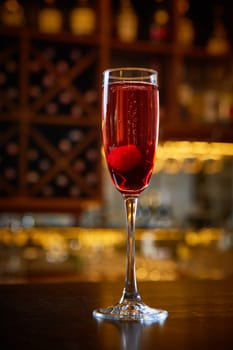 Red Cocktail in Champagne Glass near in the Bar with Amazing Blurred Background