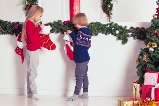 Adorable little children open their stocking gifts on Christmas morning