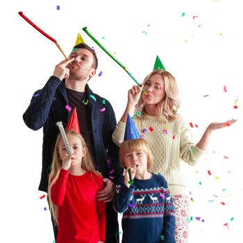 Family blowing party trumpets with confetti celebrating new year