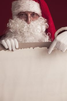 Santa Claus holding vintage paper billboard with copy space for text