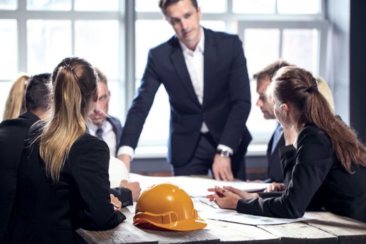 Engineers and businessmen are discussing construction projects in workplace. Construction concept.