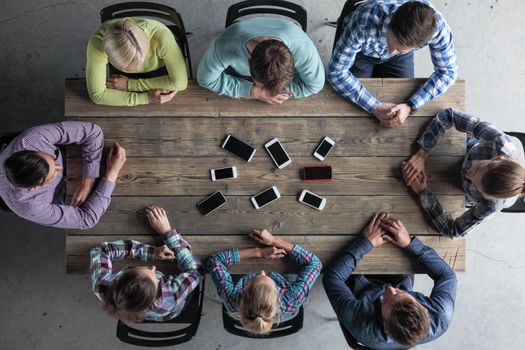 Business people not using smartphones sitting around office table