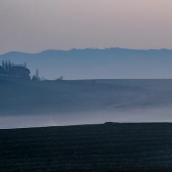 Dark to light blue in 3 layers of fields and the sky before the sunrise in Mutilva, Spain