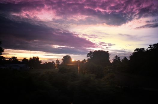 A colorful sunup above a small train station in thailand 