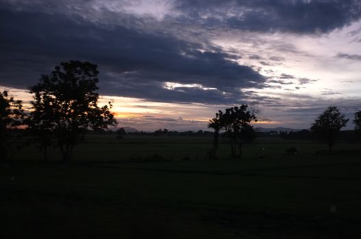 A colorful sunup above a small train station in thailand 