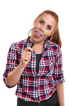 Beautiful young woman showing her magnified tongue under magnifying glass. Portrait of a smiling young girl sticking her tongue out, looking at camera, isolated on white background.