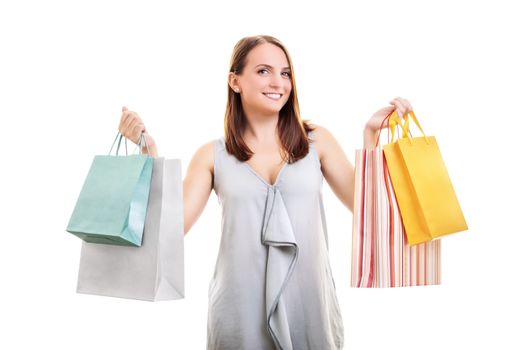 Beautiful happy young woman holding many shopping bags in both hands, isolated on white background. Successful day shopping.