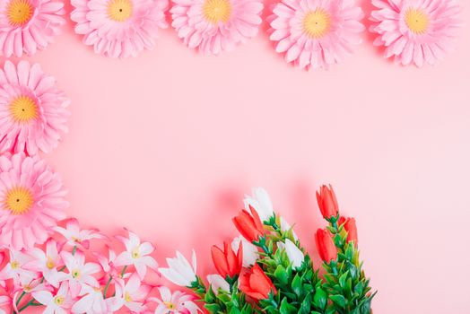 Beautiful flowers top view on pink background with copy space