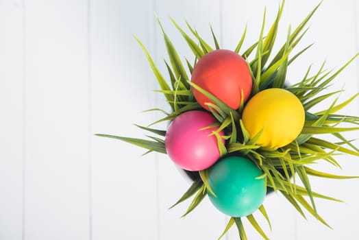 Top view of Easter eggs clean in grass on white wooden background, easter day concept