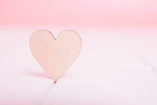 Wood heart on white wooden have pink background, valentine day concept