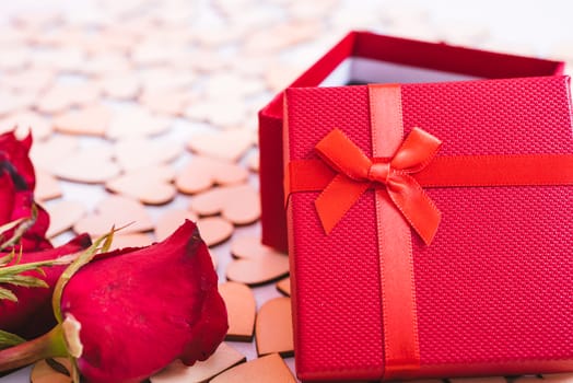 Hearts on white wooden background have a gift box and flower rose, valentine day concept