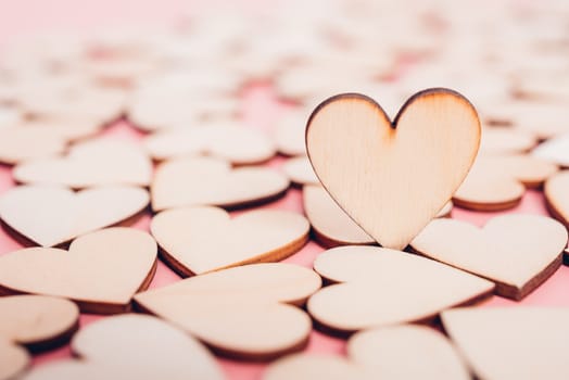 Wood hearts stand on pink background with copy space, valentine day concept