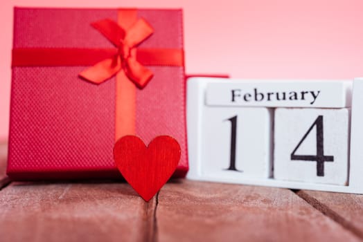 Red wood Hearts and gift box on wooden and pink background, 14 February, valentine day concept