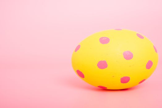 Beautiful Easter Yellow egg color on pink background, Easter day concept