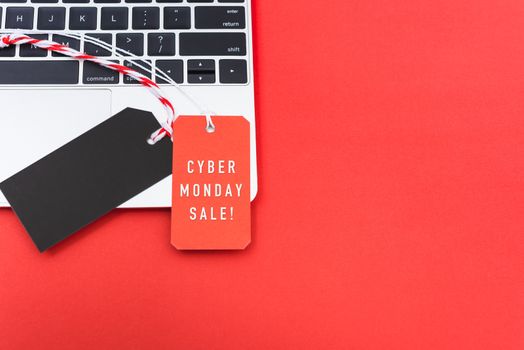 Online shopping Cyber Monday text with red tag label and Blank black red tag on laptop computer, with copy space red background