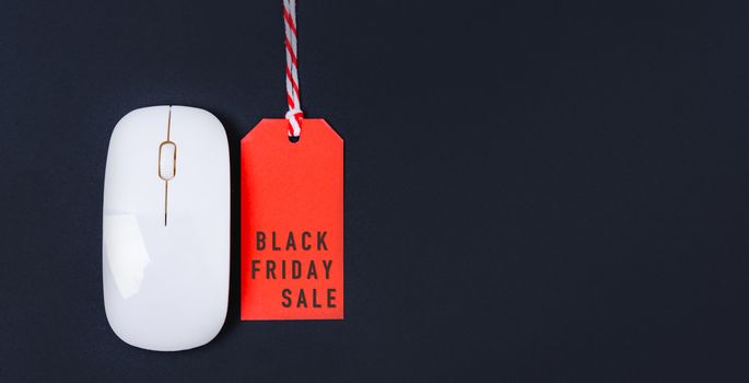 Online shopping Black friday sale text on red tag label and white mouse, with copy space on black background