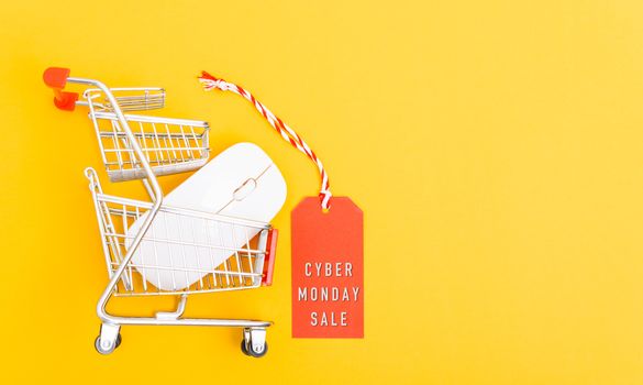 Online shopping Cyber Monday sale text on red tag label have white mouse on cart shopping, with copy space on yellow background